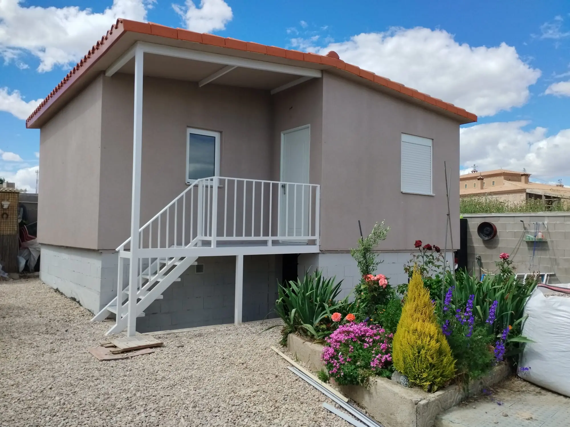 Casa modular terminada, con cubierta de teja y porche de acceso